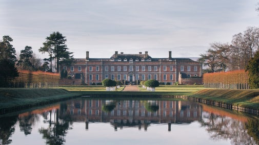 A view across the canal towards the house at Erddig, Clwyd, which is reflected on the water.
